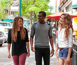 Three students walking downtown
